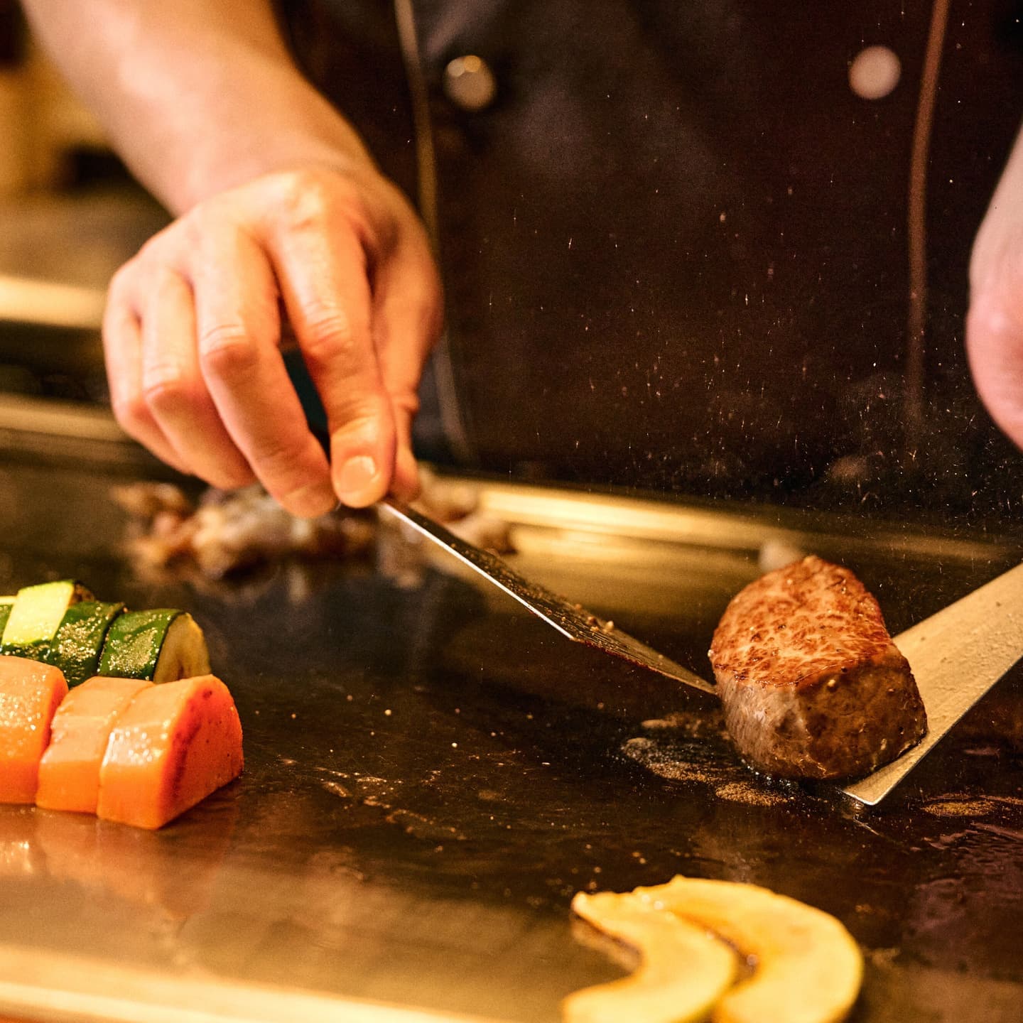 鉄板の上で豪快に焼かれる肉料理と立ち上る熱い湯気、弾ける脂の躍動感あふれるシズルカット no.3