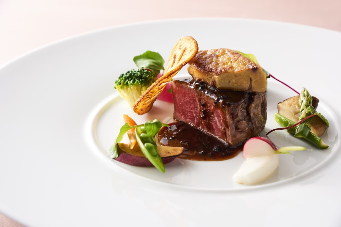 白い皿に美しく盛り付けられた牛フィレ肉とフォアグラのステーキ、精密なライティングによる料理撮影