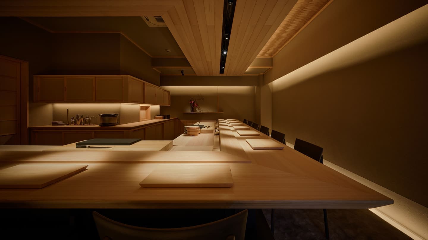 直線的な白木のカウンターと間接照明が織りなす高級和食店のモダンな内観全景、静謐な空気感と奥行きを強調した広角空間撮影