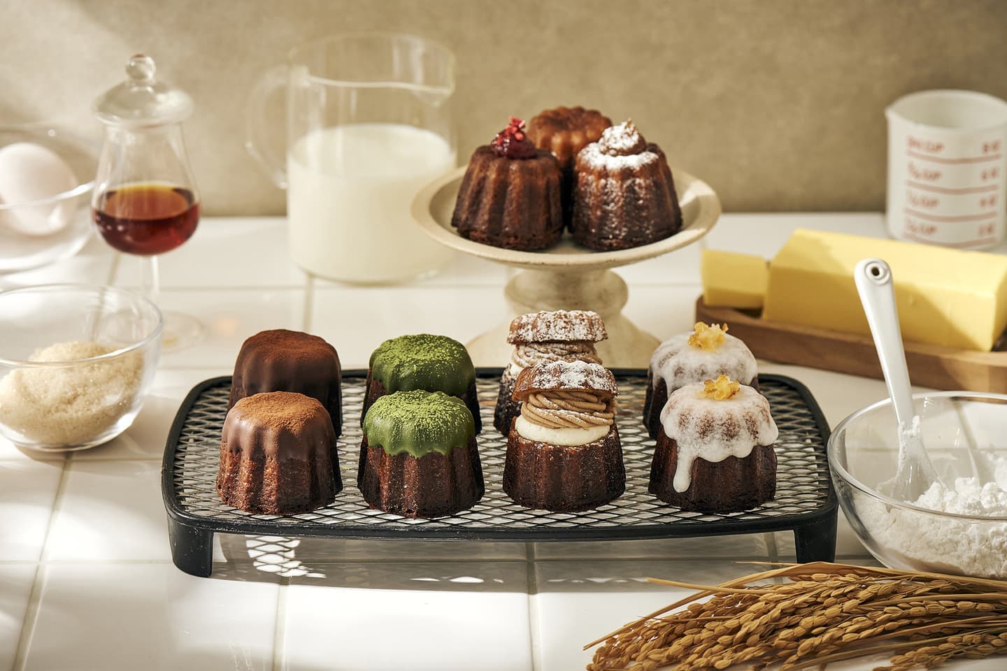 多彩なトッピングのカヌレが並ぶ広告用イメージ。高精度LEDライティングによる柔らかな光の中で、素材の質感と色彩が調和する緻密なフードスタイリング撮影