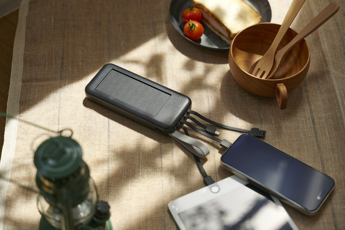 朝の光が差し込むリネン上のモバイルバッテリーとデジタルデバイス。無機質なガジェットを、温かみのある生活空間に馴染ませた、D2Cブランド向けのスタイリング撮影。