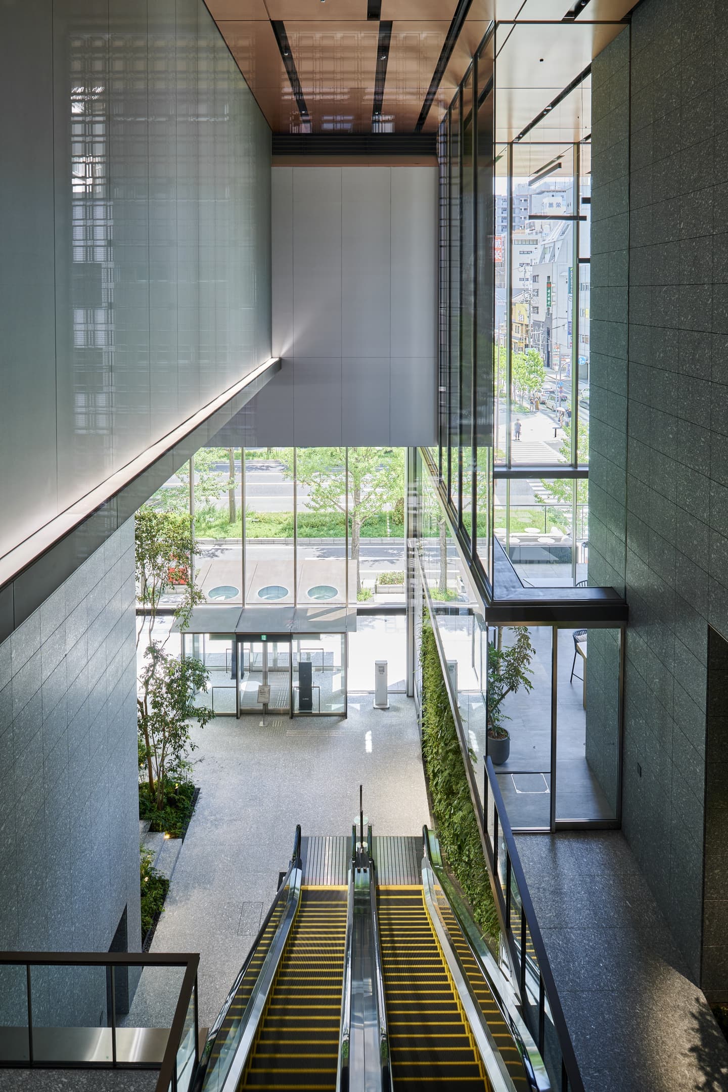 ビル内観の吹き抜け空間。高低差を活かしたアングルと、自然光が差し込む開放的な竣工写真撮影。