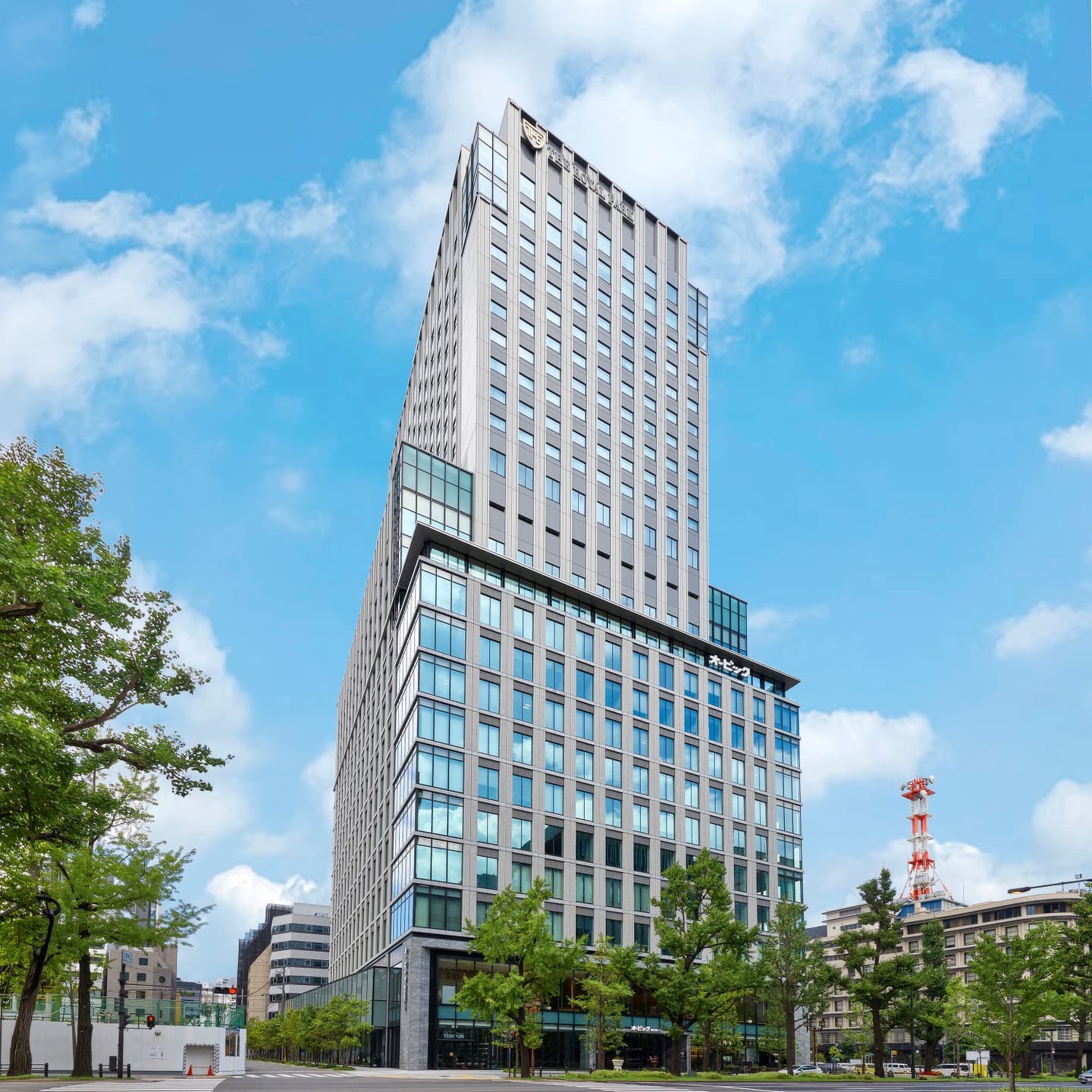 高層ビルの外観竣工撮影。超広角レンズによるパース歪みを補正し、ビルのエッジと空のコントラストを際立たせた建築写真。