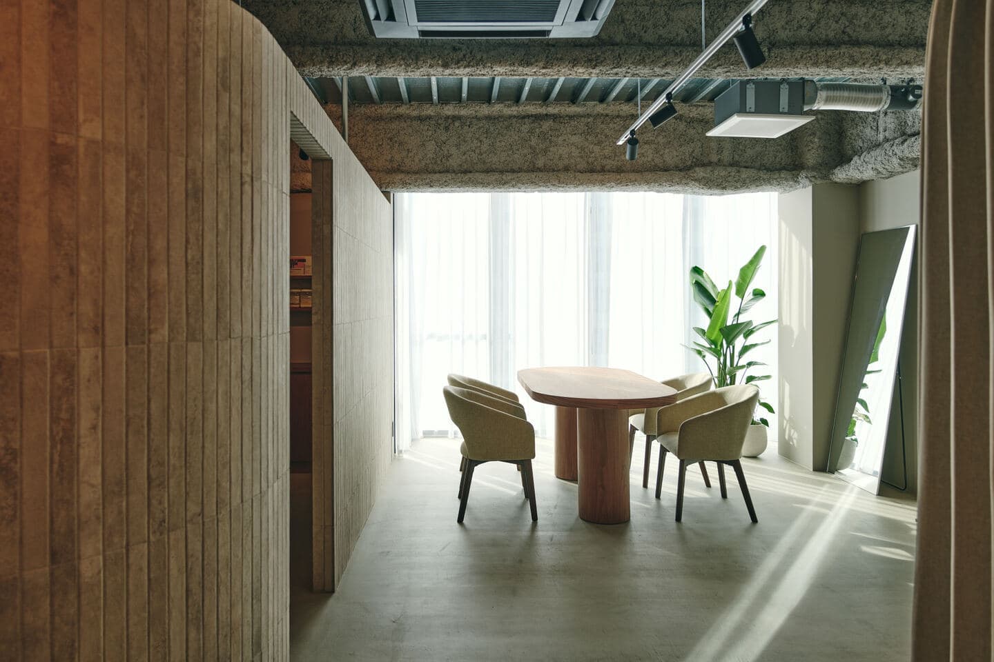 エステサロンの内装竣工写真。コンクリートの質感と柔らかな間接照明が調和する、静謐で上質なプライベート空間の撮影事例。