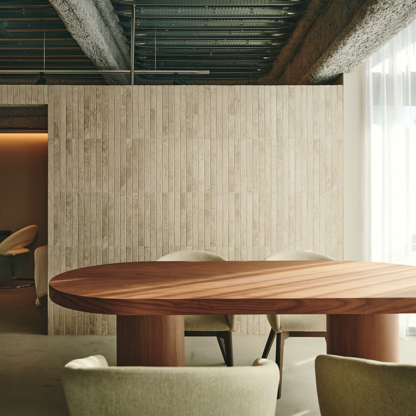 エステサロンのレセプション・カウンセリングスペースの撮影事例。コンクリートの梁と柔らかなカーテンの質感を対比させ、開放感と上質さを両立させた空間構成。