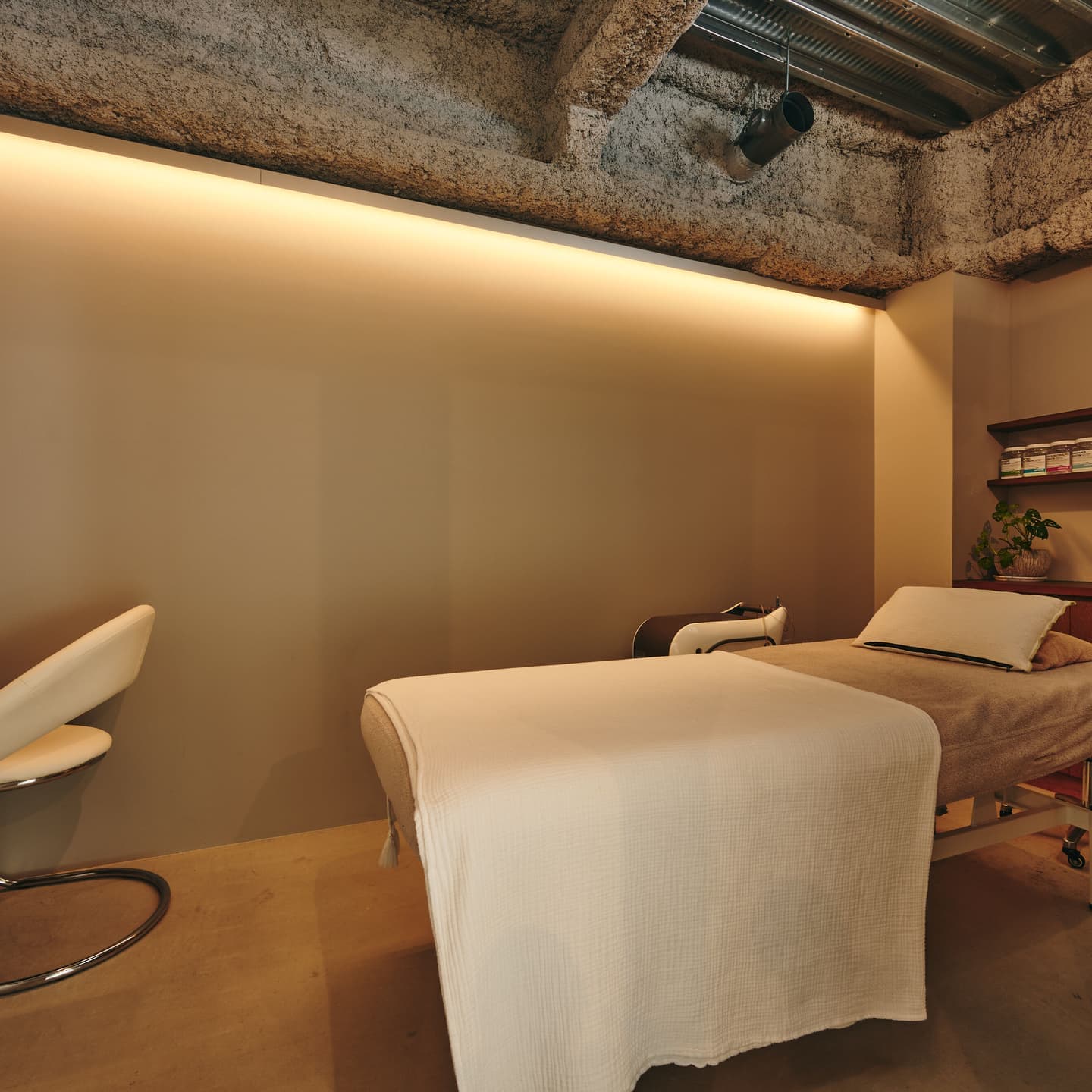 プライベートサロンの施術ルーム撮影。間接照明によるリラックス効果と、清潔感のあるベッドメイキングまでを緻密なライティングで捉えた内観ポートフォリオ。